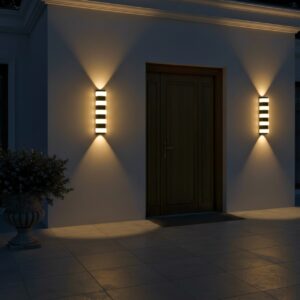 Modern black outdoor LED wall light, 12W, glowing warm up and down on a luxury home's exterior at night.