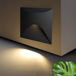 A modern, black, square-shaped step light with a curved, flowing front design