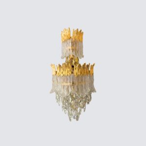 A beautifully lit, ornate crystal and gold wall sconce with an E14 bulb holder