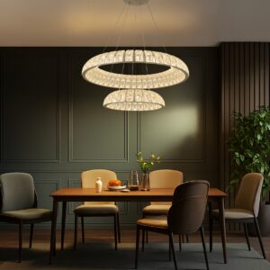 Modern two-tier crystal LED chandelier with chrome finish hanging over a dark wood dining table in a room with dark green wainscoting.