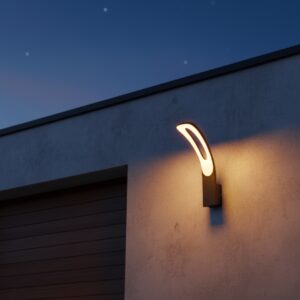 Modern black LED outdoor wall light with a unique curved crescent shape, casting a warm glow on a white exterior wall at dusk.