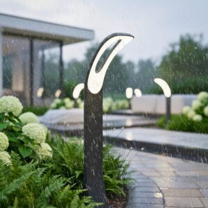Luxury black curved LED 3000K bollard light on a wet garden pathway during a rainy morning, with water dew on the fixture and other pathway lights.