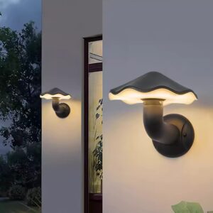Modern black mushroom-shaped outdoor wall light or sconce mounted on a white exterior wall providing warm LED illumination for a porch or patio