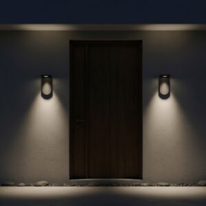 Modern black outdoor wall light with warm COB LED glow on a luxury house exterior at dusk, accenting a patio area.