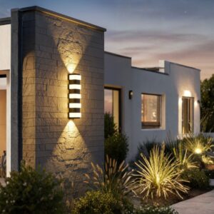 Modern black outdoor LED wall light, 12W, glowing warm up and down on a luxury home's exterior at night.