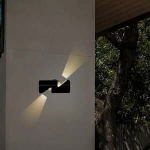 A modern black up-down wall light mounted on a gray wall, casting warm white light both upwards and downwards. The light is suitable for both indoor and outdoor use.