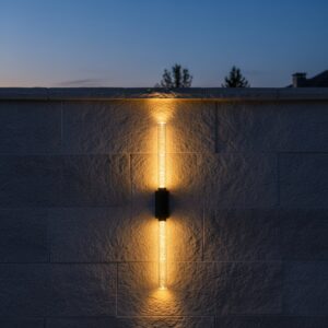 Modern outdoor 6W LED wall light with bubble glass diffuser, casting warm up and down light on a luxury home's exterior wall at night.