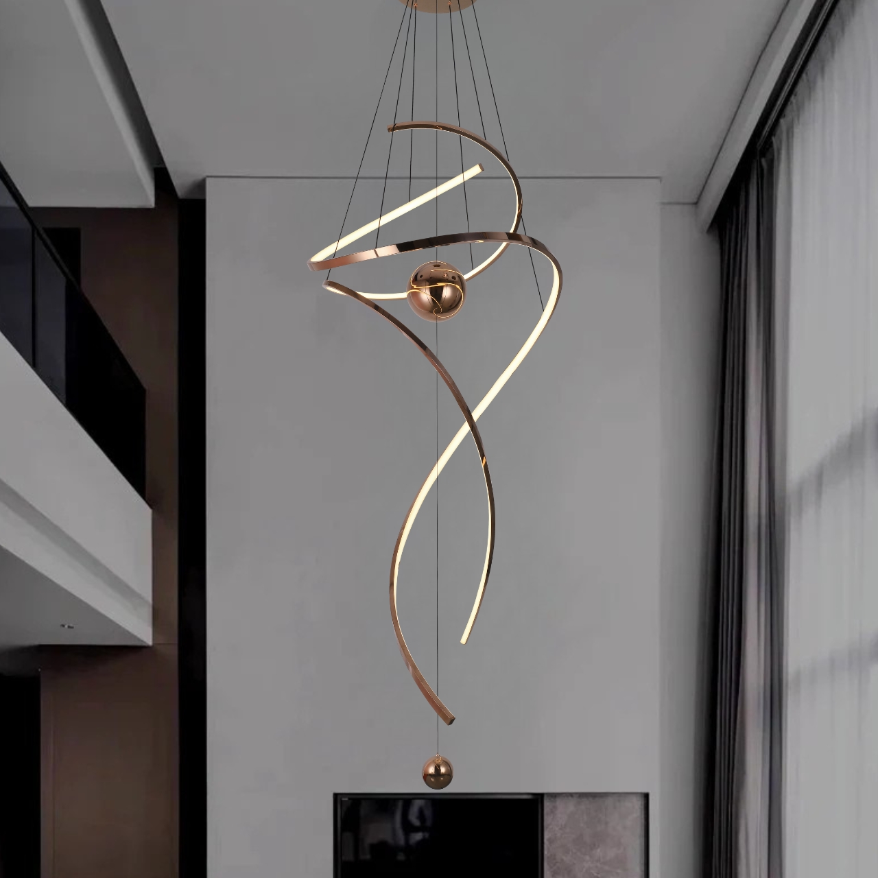 Modern spiral LED pendant light for high ceilings with metallic finish and spherical accents in a contemporary home foyer
