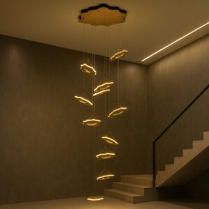 Luxury modern high ceiling living area with staircase and a large gold cloud-design pendant chandelier.